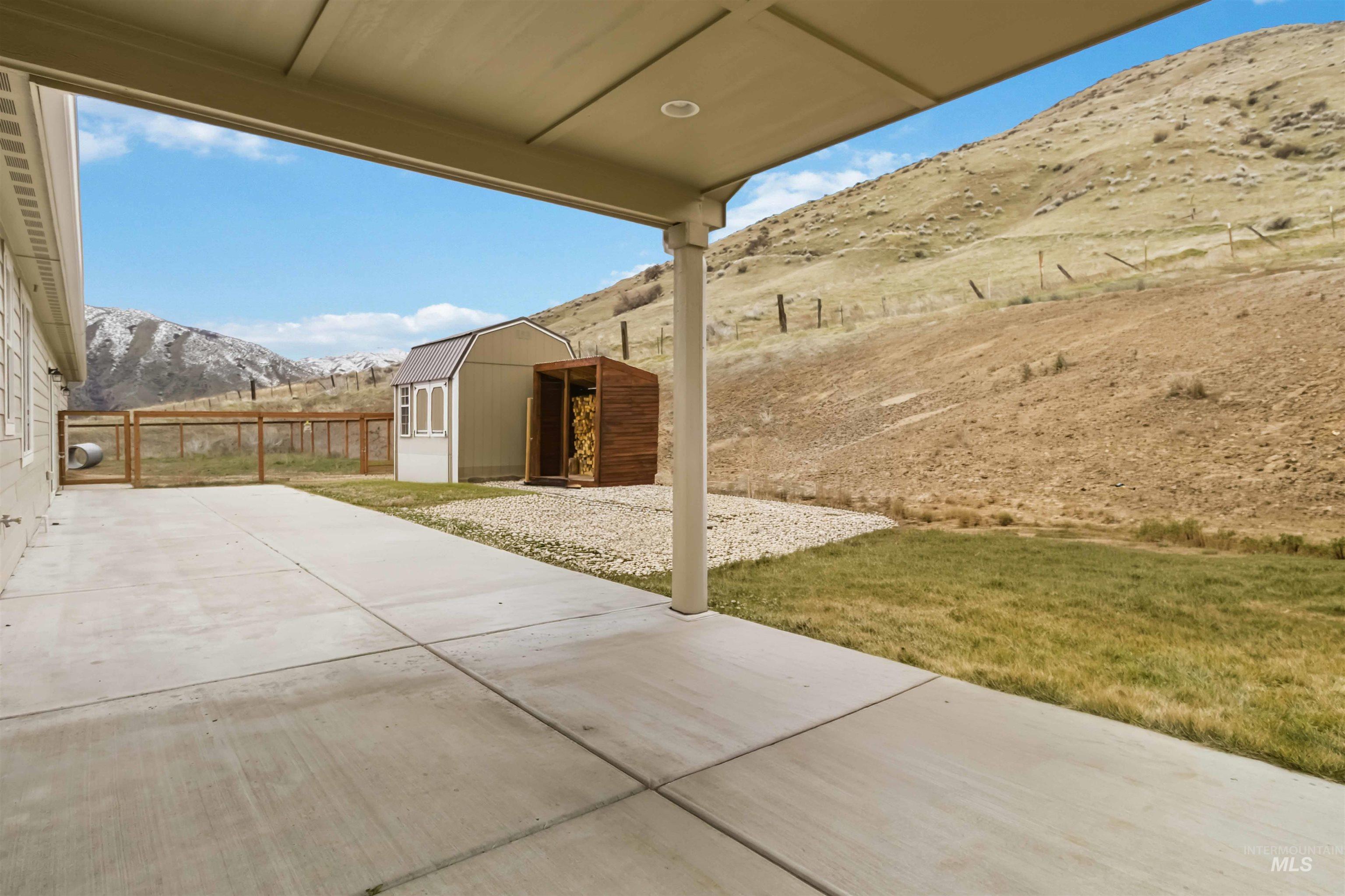 25 River Ridge Horseshoe Bend, ID 83629 - Photo 38 of 50 Fenced backyard with a mountain view, a patio, and a shed