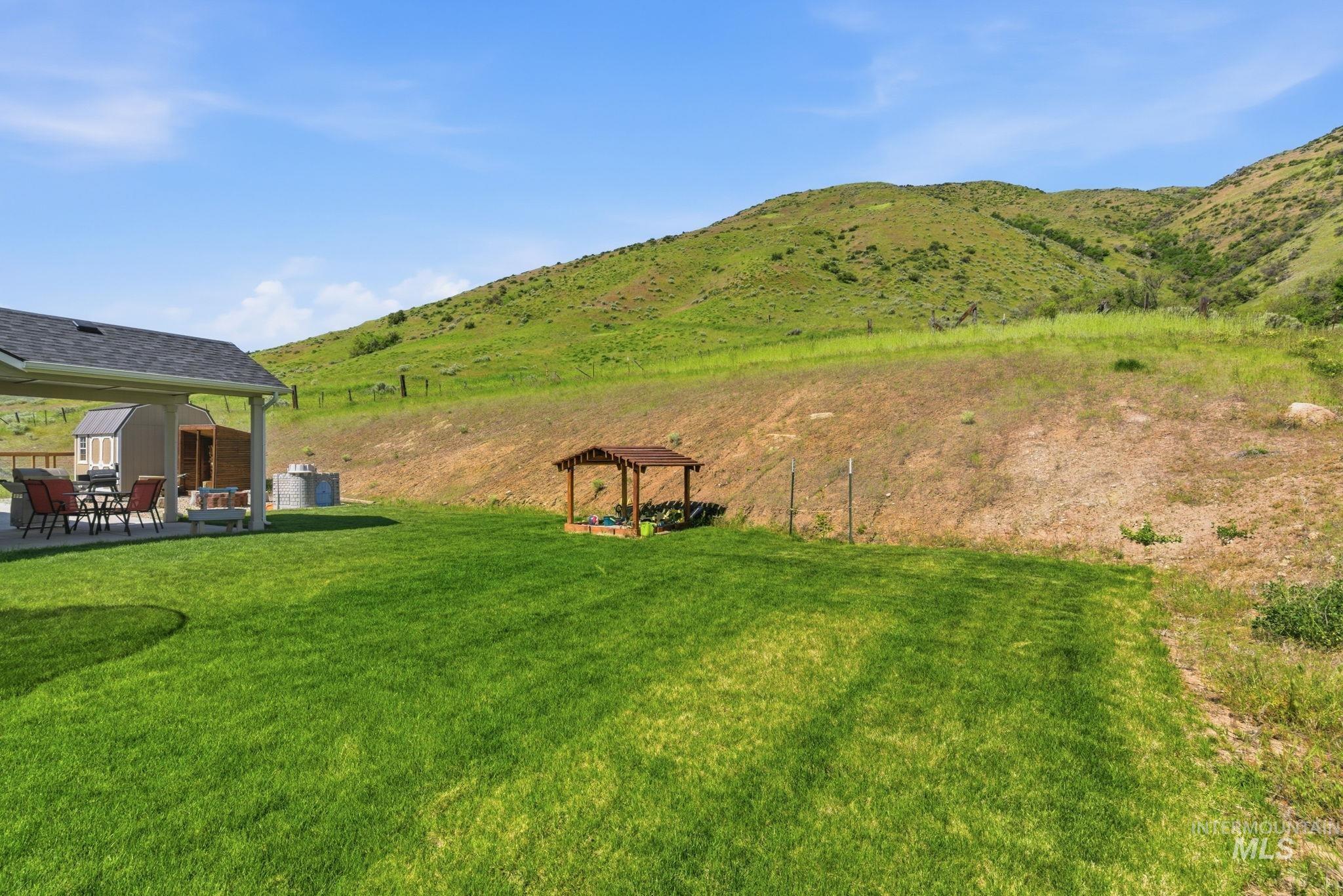 25 River Ridge Horseshoe Bend, ID 83629 - Photo 40 of 50 Expansive green lawn with a covered patio, featuring a storage shed and a small wooden pergola