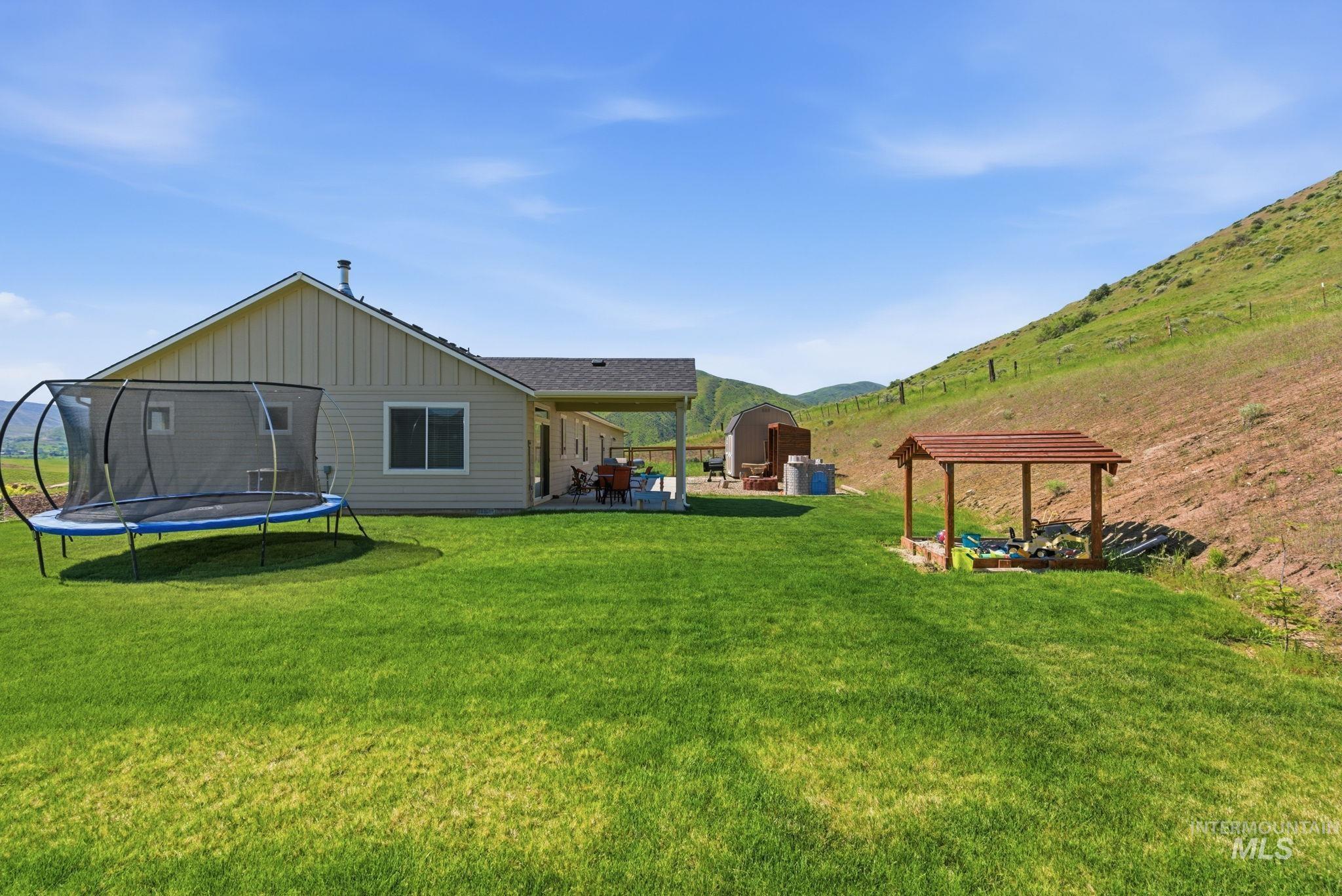 25 River Ridge Horseshoe Bend, ID 83629 - Photo 41 of 50 Expansive green lawn with a covered patio, gabled roofline, and a separate shaded structure