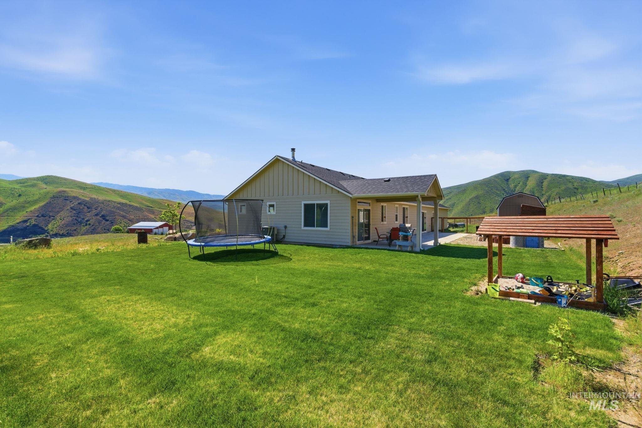 25 River Ridge Horseshoe Bend, ID 83629 - Photo 43 of 50 Expansive backyard featuring a manicured lawn, a covered patio, and distant rolling hills