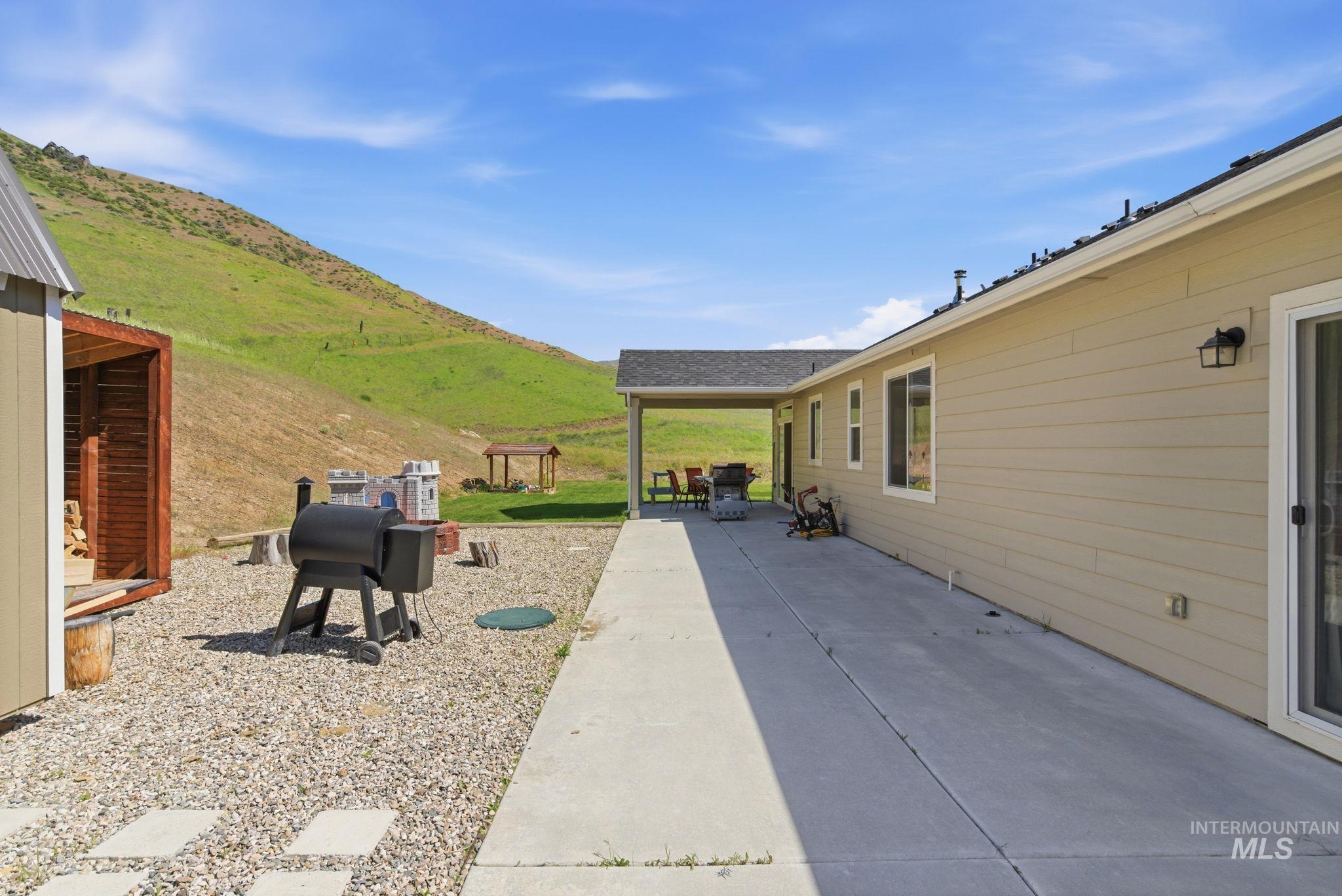 25 River Ridge Horseshoe Bend, ID 83629 - Photo 44 of 50 Expansive concrete patio with a covered outdoor area, tan horizontal siding, and multiple windows