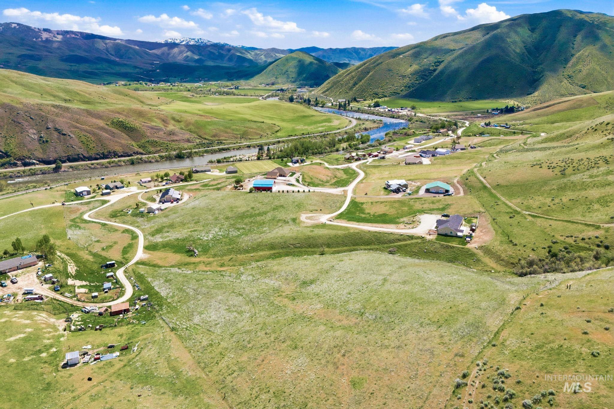 25 River Ridge Horseshoe Bend, ID 83629 - Photo 46 of 50 Expansive green hills surrounding a winding river and scattered residential properties, with distant mountains providing a scenic backdrop