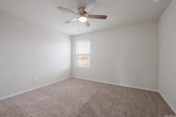 an empty room with a window and a ceiling fan
