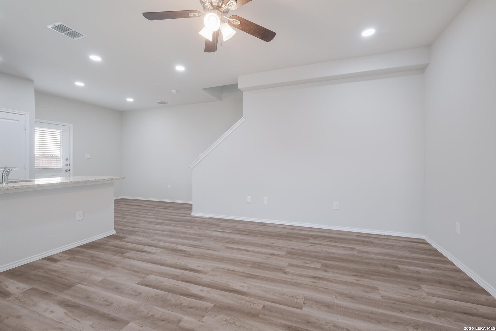 7356 Misty Ridge Drive, Unit 101 Converse, TX 78109 - Photo 3 of 18 an empty room with wooden floor and windows
