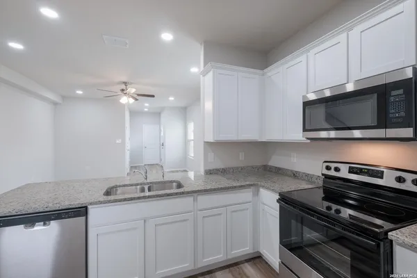 a kitchen with kitchen island granite countertop stainless steel appliances and cabinets