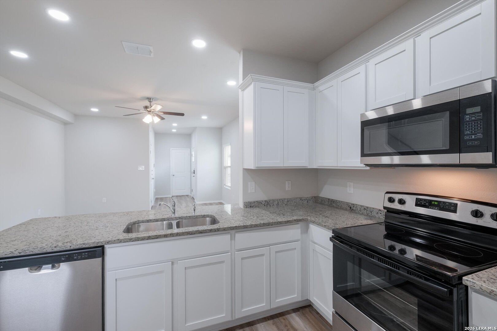 7356 Misty Ridge Drive, Unit 101 Converse, TX 78109 - Photo 7 of 18 a kitchen with kitchen island granite countertop stainless steel appliances and cabinets