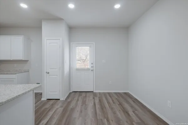 a view of empty room with wooden floor and cabinet