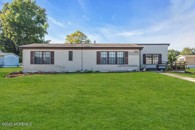 a front view of house with yard and green space