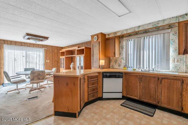 a kitchen with stainless steel appliances granite countertop a stove a sink and dishwasher with wooden cabinets