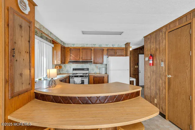 a living room with stainless steel appliances granite countertop furniture and a wooden floor