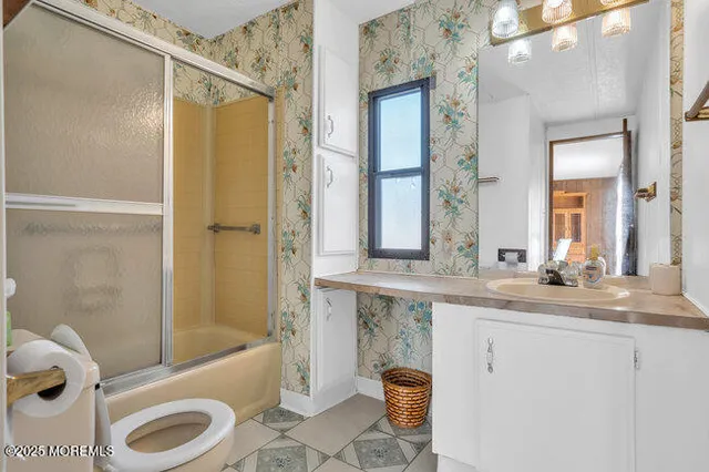 a bathroom with a granite countertop bathtub sink vanity mirror and toilet