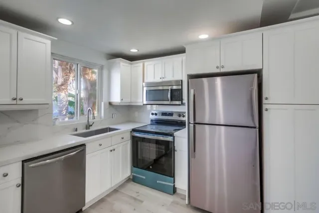 a kitchen with a sink a refrigerator and cabinets
