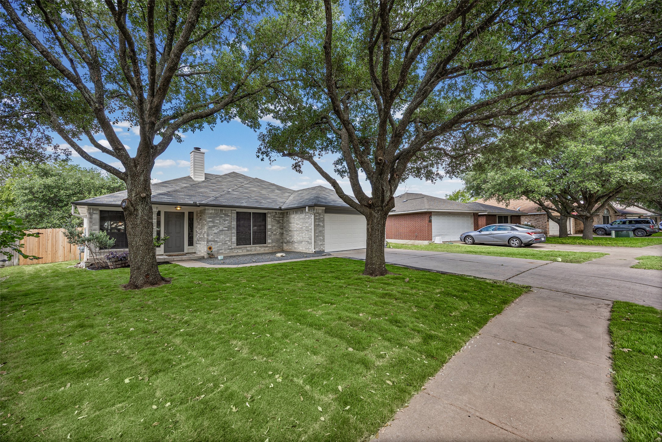 1524 Lochaline Loop Pflugerville, TX 78660 - Photo 5 of 22 Mature trees shade this charming brick home with an integrated garage and neatly kept lawn.