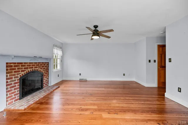 a view of empty room with wooden floor and floor to ceiling window