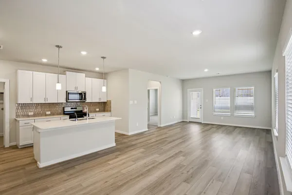 a kitchen with stainless steel appliances kitchen island wooden floors and white cabinets