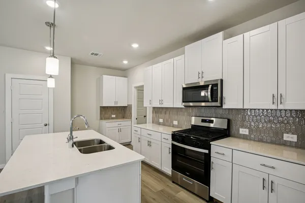 a kitchen with a sink a stove and cabinets