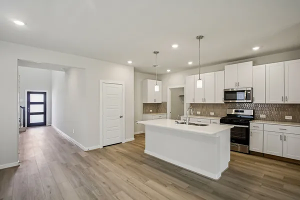 a kitchen with white cabinets and stainless steel appliances