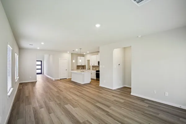 a view of a kitchen with wooden floor and a window