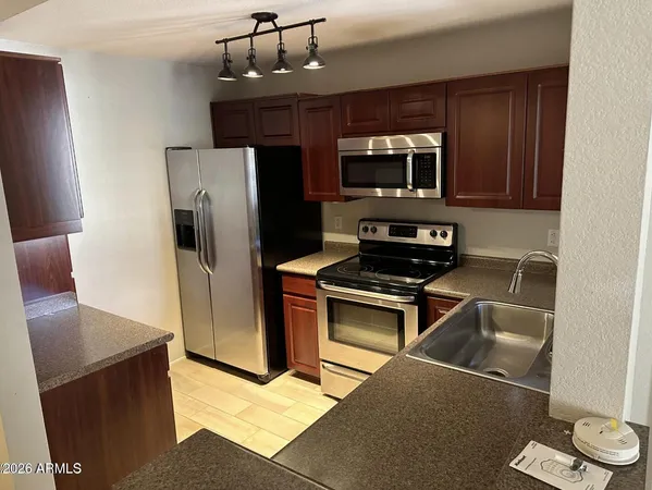 a kitchen with stainless steel appliances granite countertop a refrigerator and a stove top oven