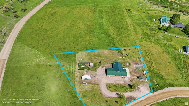 8066 North Valley View Heights Preston, ID 83263 - Photo 33 of 34 Aerial overview showcasing a property with a green-roofed structure, surrounded by expansive green terrain-boundary lines are for visual only