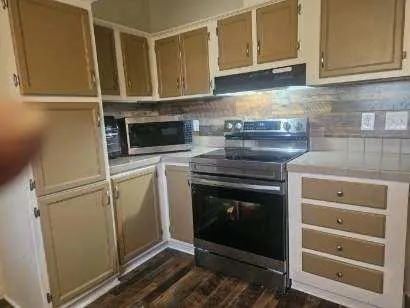 a kitchen with granite countertop white cabinets stainless steel appliances and sink