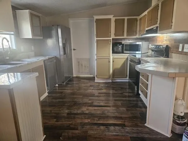 a kitchen with granite countertop a refrigerator and a sink