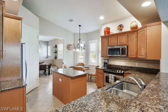 a kitchen with granite countertop a sink stove and cabinets