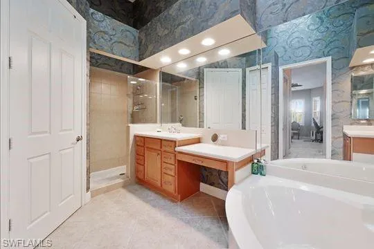 a bathroom with a double vanity sink mirror and a bathtub