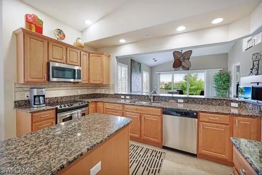 a kitchen with stainless steel appliances granite countertop a sink stove and microwave