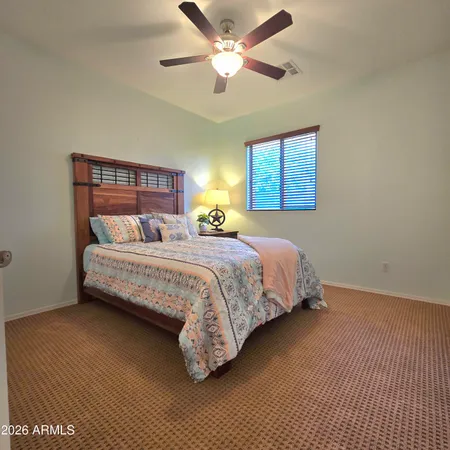 a bedroom with a bed and a ceiling fan