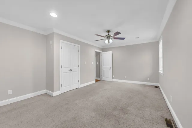 a view of an empty room with a chandelier fan