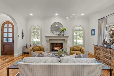 a living room with fireplace furniture and a wooden floor