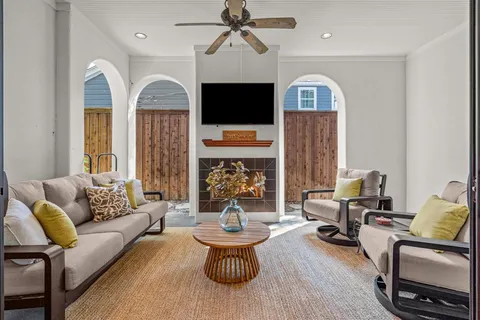 a living room with furniture a fireplace and a flat screen tv