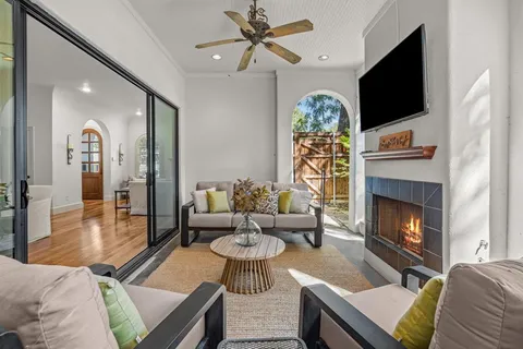 a living room with furniture a dining table wooden floor and a chandelier
