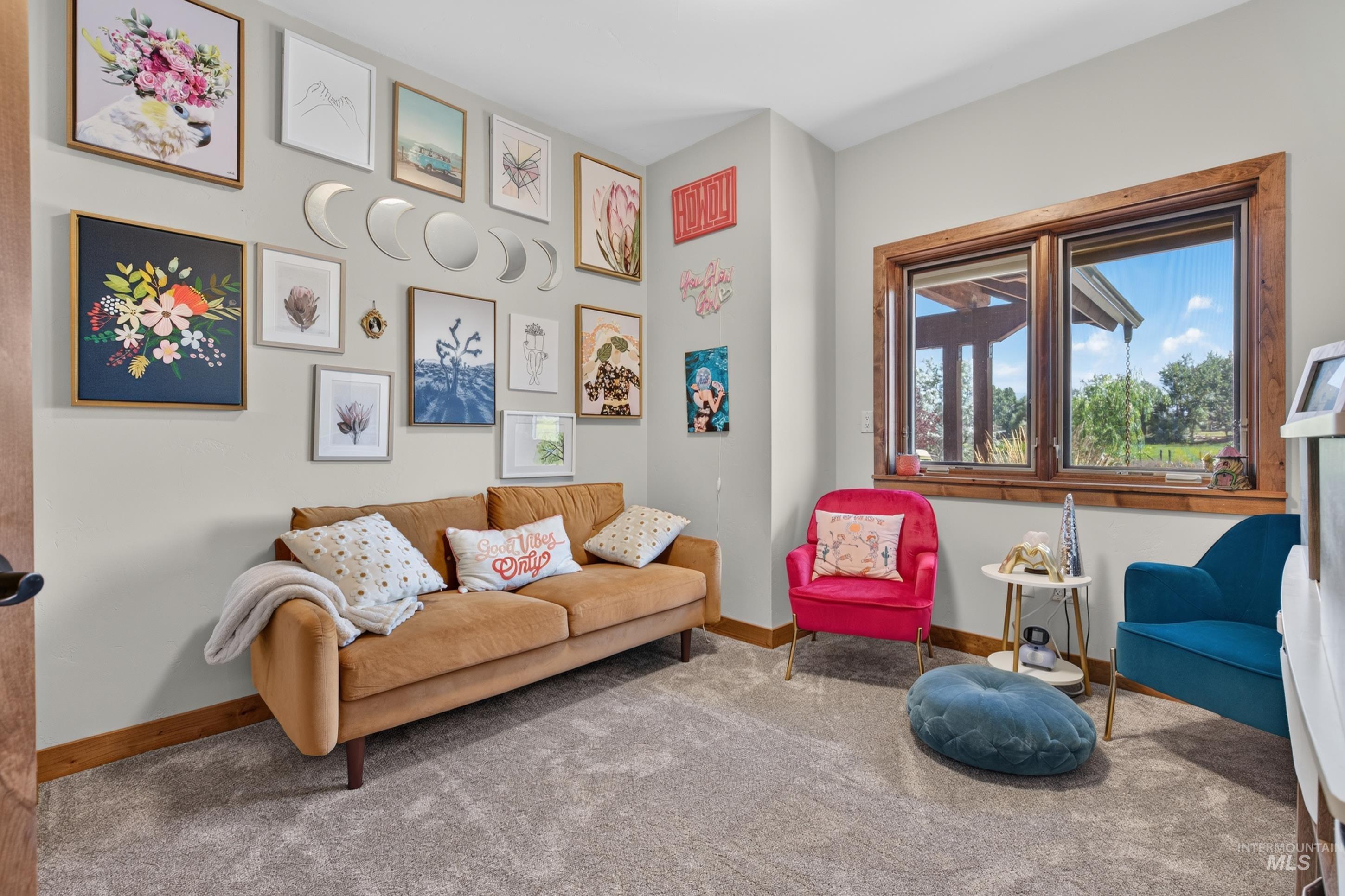 63 Mountain View Road Salmon, ID 83467 - Photo 23 of 50 Carpeted room featuring a large window with natural wood trim, light gray walls, and a wood-finish baseboard