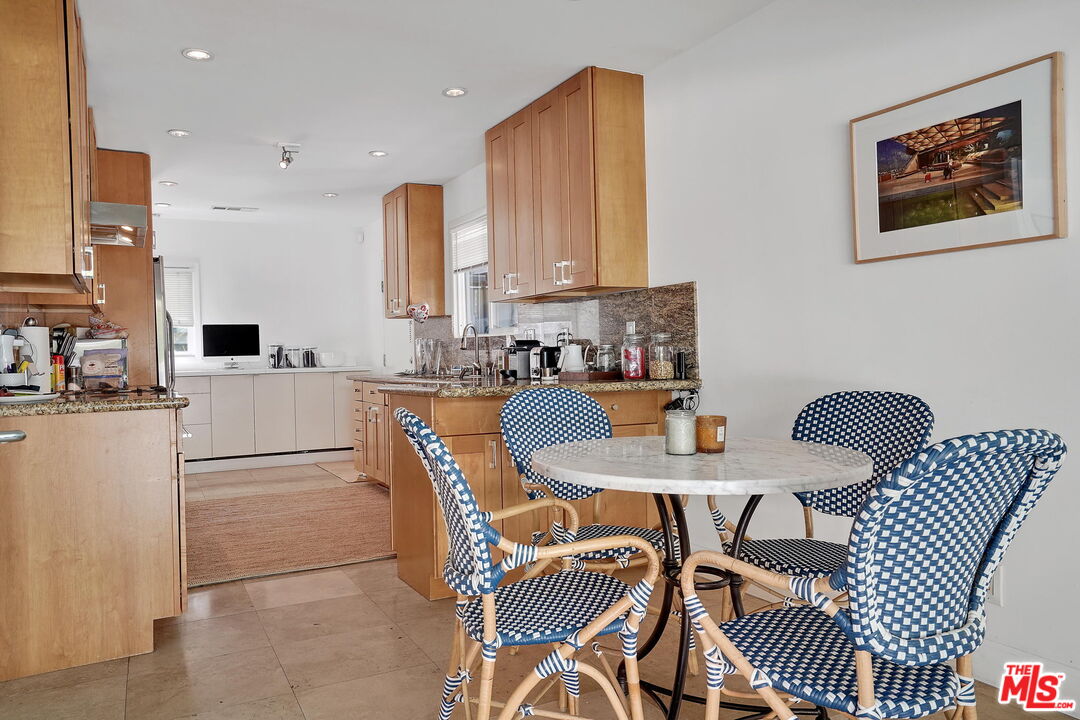 1066 Chantilly Road Los Angeles, CA 90077 - Photo 8 of 12 a kitchen with a table chairs and a refrigerator