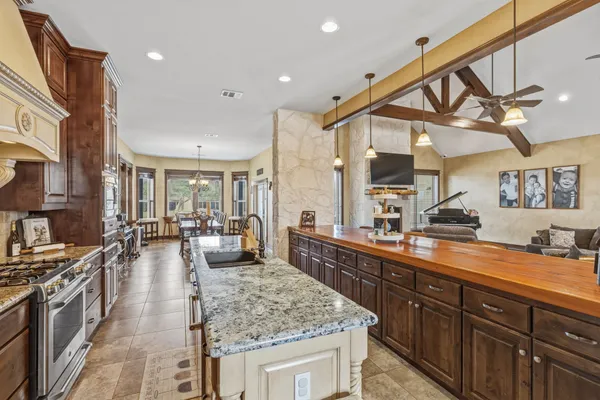 a large kitchen with stainless steel appliances granite countertop a lot of counter space and wooden floor