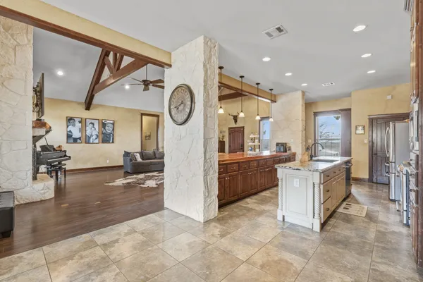 a large white kitchen with a large window and refrigerator