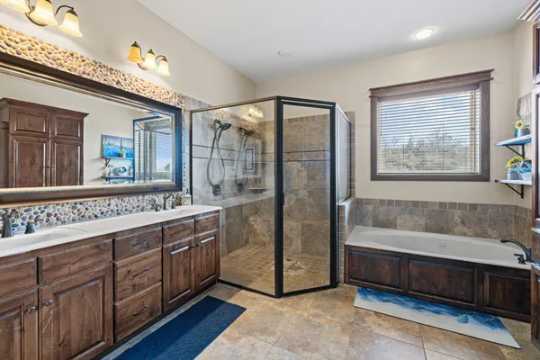 a spacious bathroom with a double vanity sink a large mirror and a bathtub