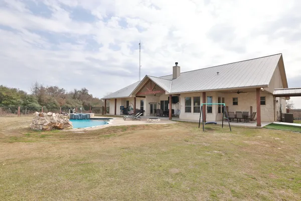 a view of a house with backyard and sitting area