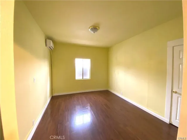 a view of a livingroom with wooden floor and a window