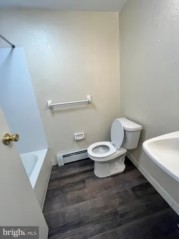 a white toilet sitting next to a white sink and vanity
