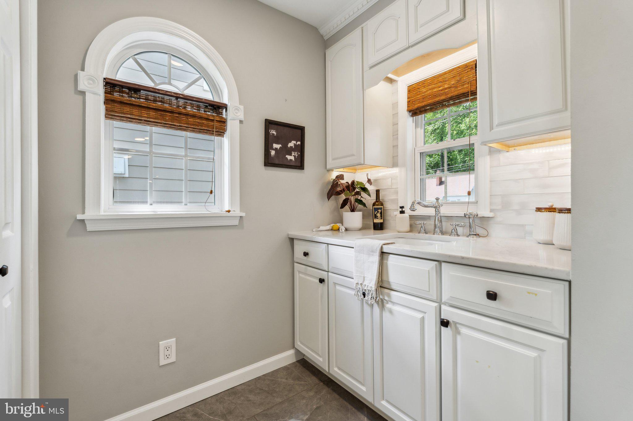 703 Roxboro Road Rockville, MD 20850 - Photo 16 of 55 a view of bathroom with a sink a window and a wooden floor