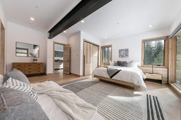 a spacious bedroom with a bed couch and a large window