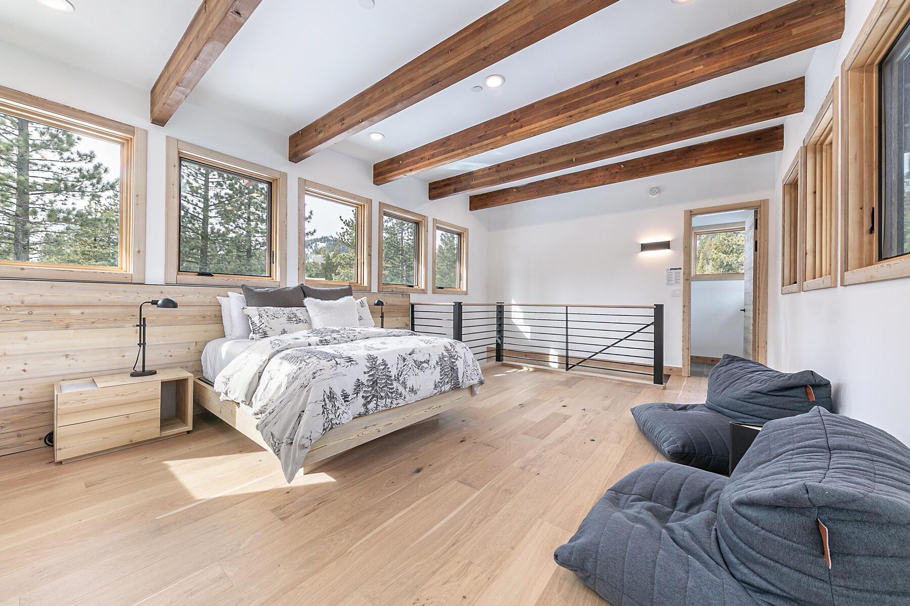 225 Smiley Court Olympic Valley, CA 96146 - Photo 18 of 28 a spacious bedroom with a bed couch and a large window