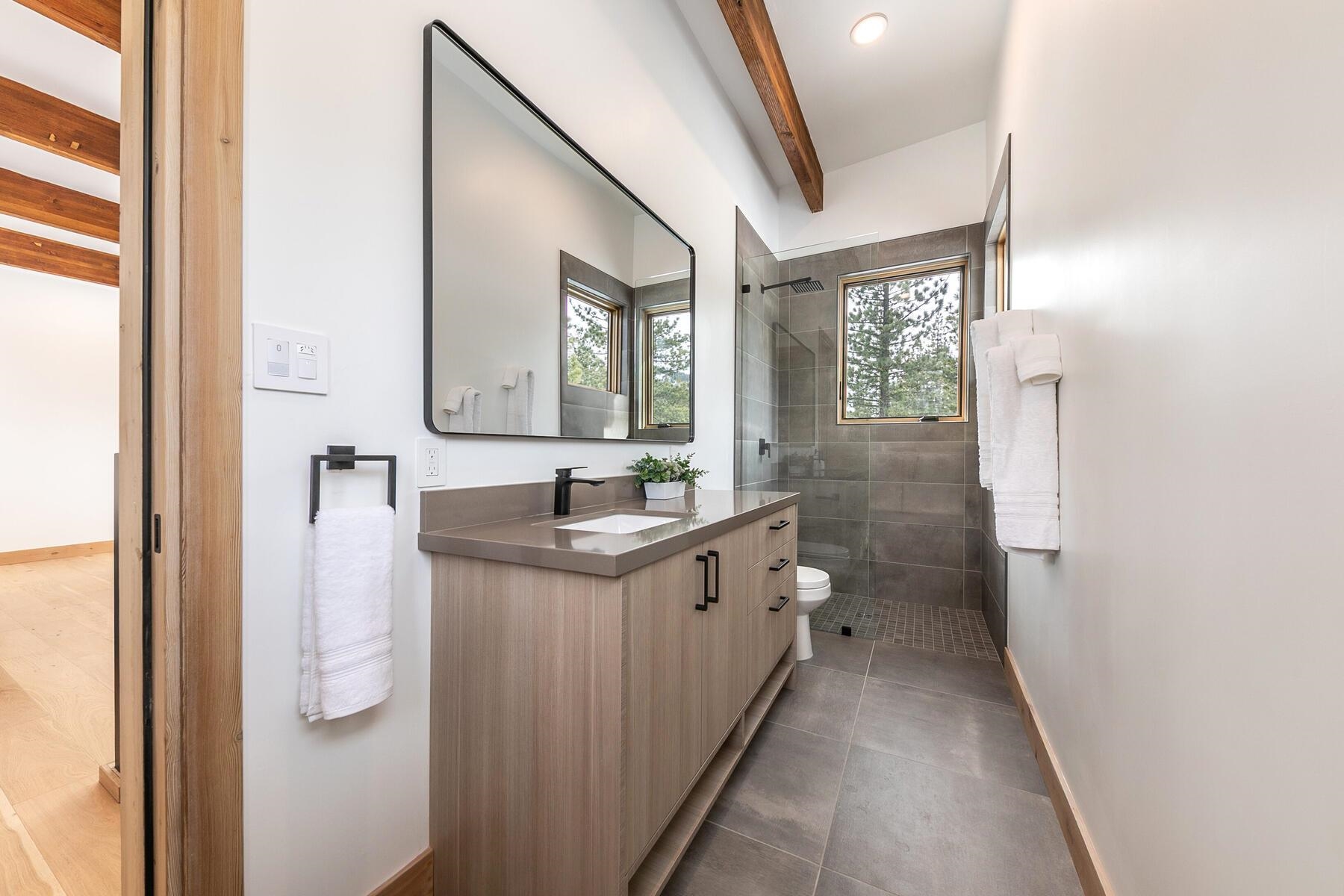225 Smiley Court Olympic Valley, CA 96146 - Photo 20 of 28 a bathroom with a granite countertop sink a mirror and a shower