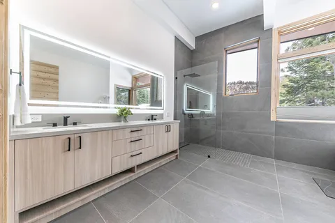 a bathroom with a granite countertop sink a mirror and a shower