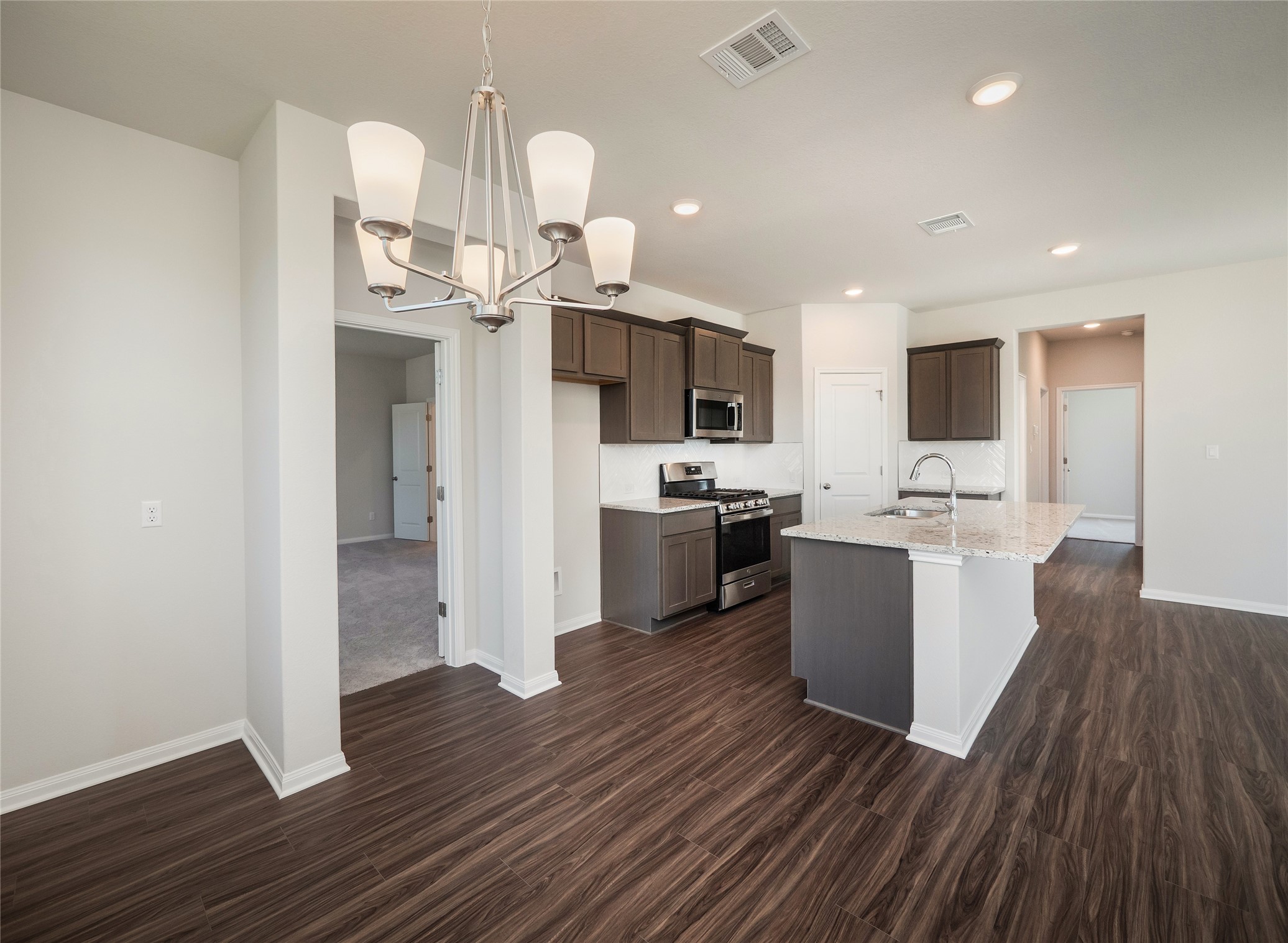 181 Soldier Street Kyle, TX 78640 - Photo 12 of 37 a kitchen with a sink cabinets stainless steel appliances and wooden floor