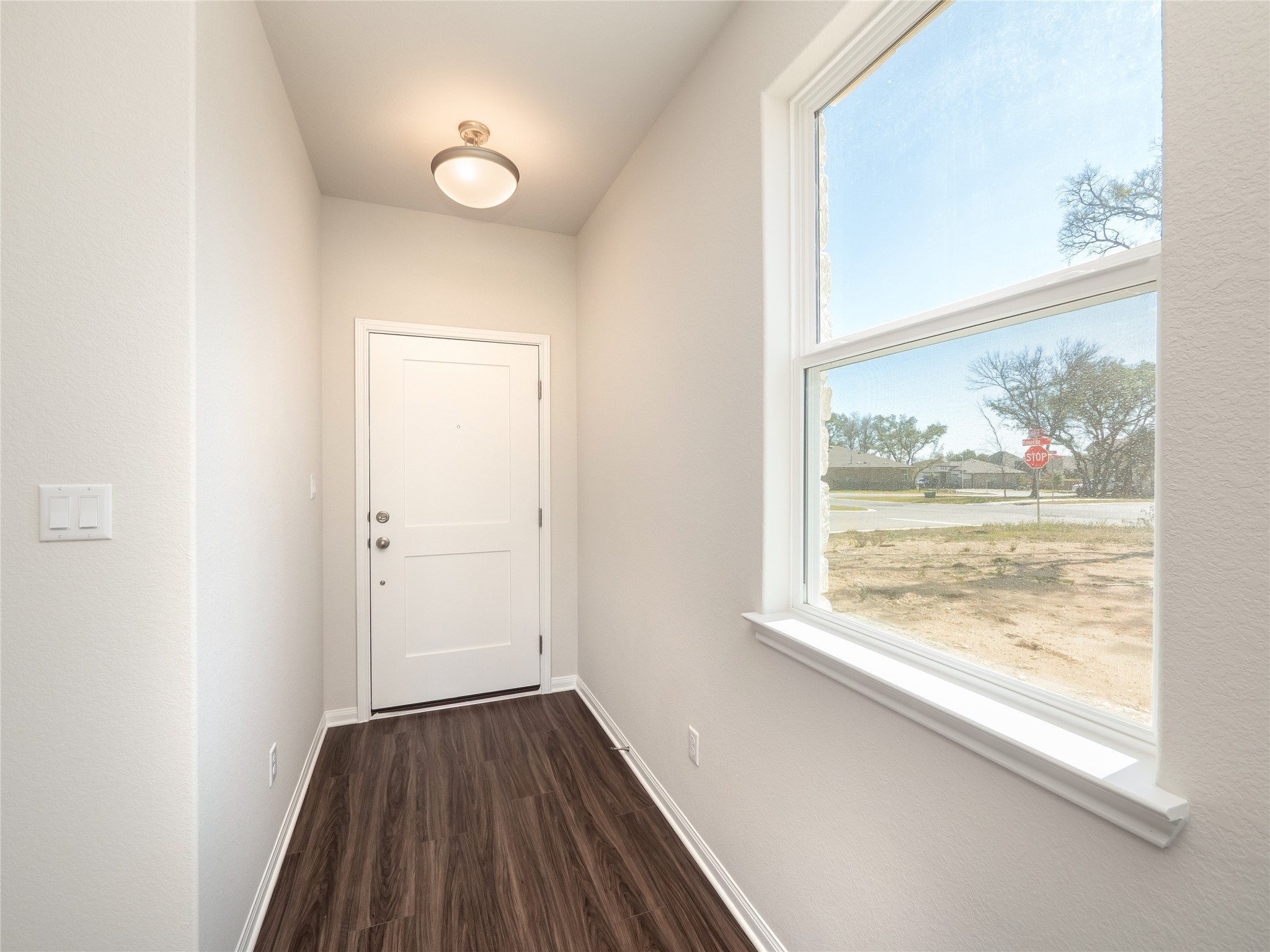 181 Soldier Street Kyle, TX 78640 - Photo 3 of 37 an empty room with wooden floor and windows