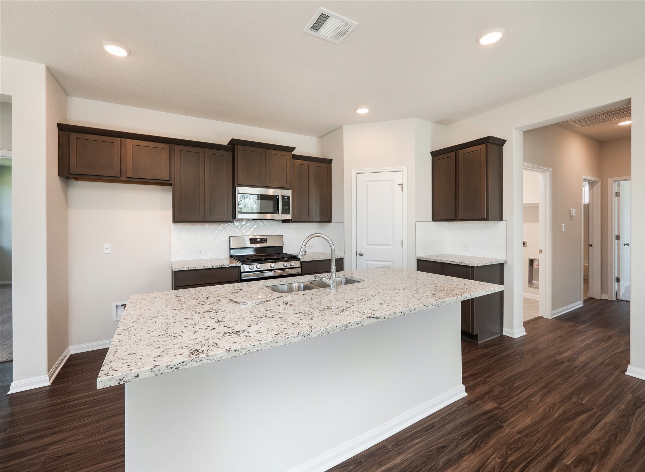 181 Soldier Street Kyle, TX 78640 - Photo 7 of 37 a view of a kitchen with kitchen island a sink stainless steel appliances and cabinets